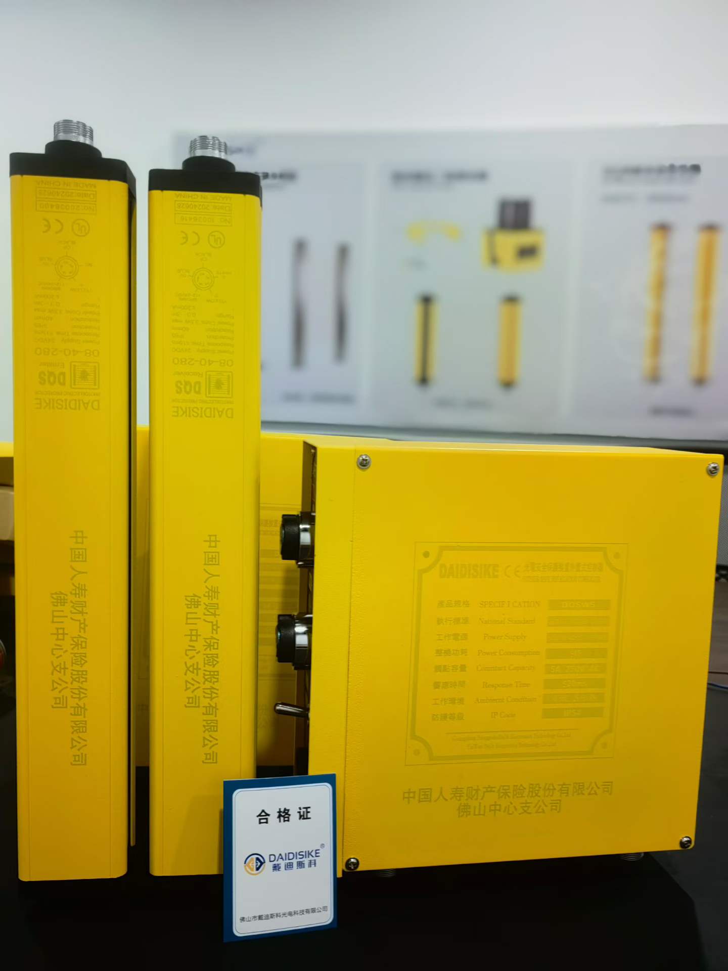 DQS光栅、控制器与戴迪斯科合格证摆在一起，合格证印有中国人寿财产保险佛山中心支公司字样。